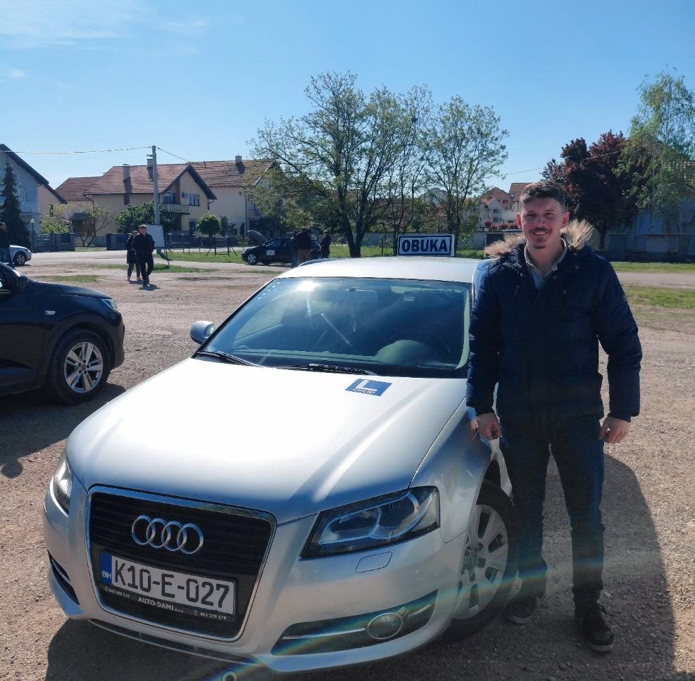Kandidat pored automobila Autoškole Mitrović & Tea sa oznakom OBUKA